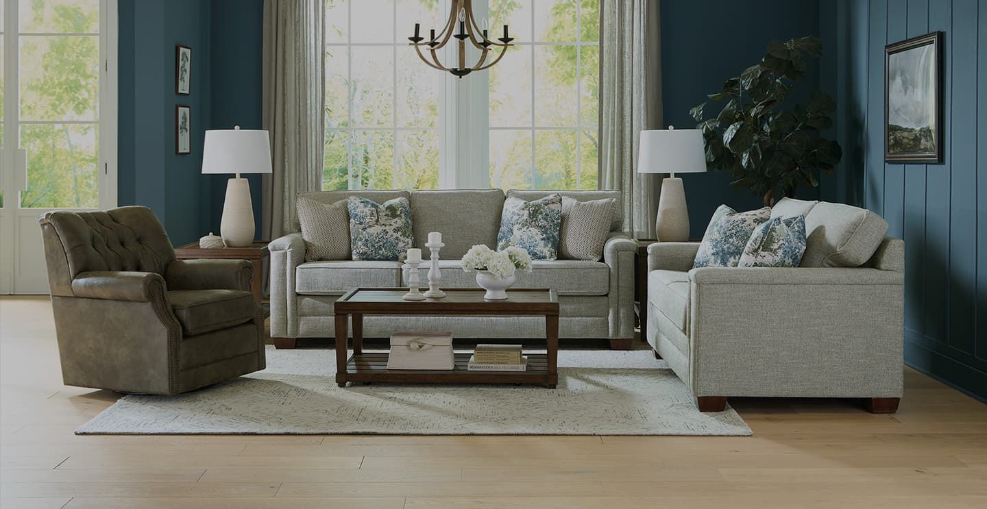 England Furniture sofa, loveseat, and swivel recliner styled in a blue-paneled living room with a wood coffee table